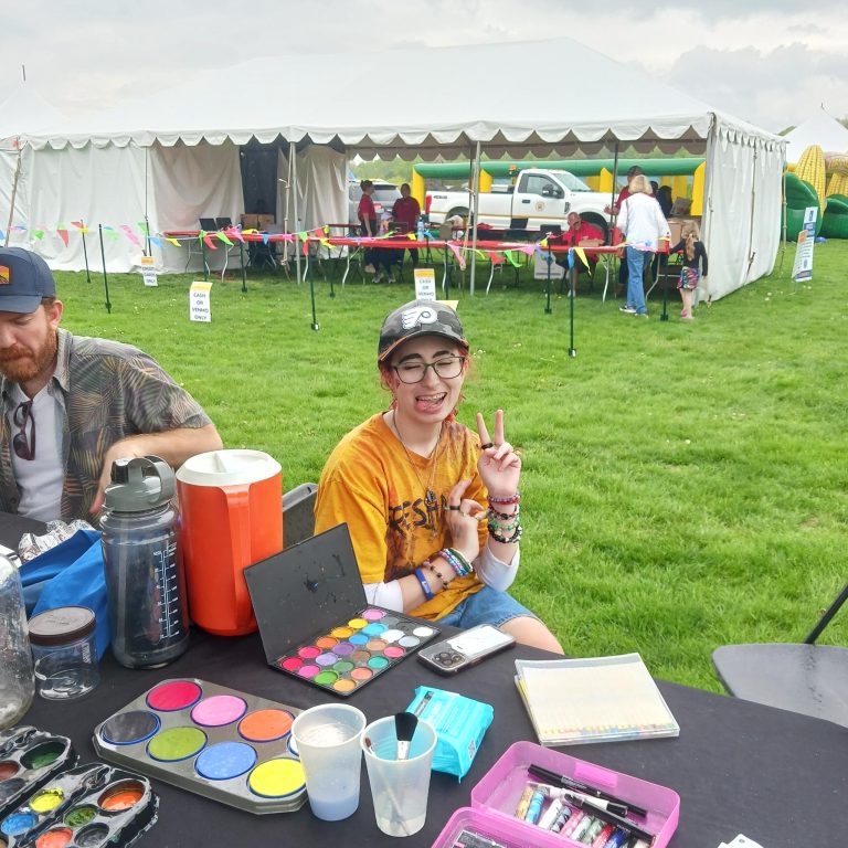 Our Young-Board Volunteer Malcolm with the Board President Mike setting up the face-painting station